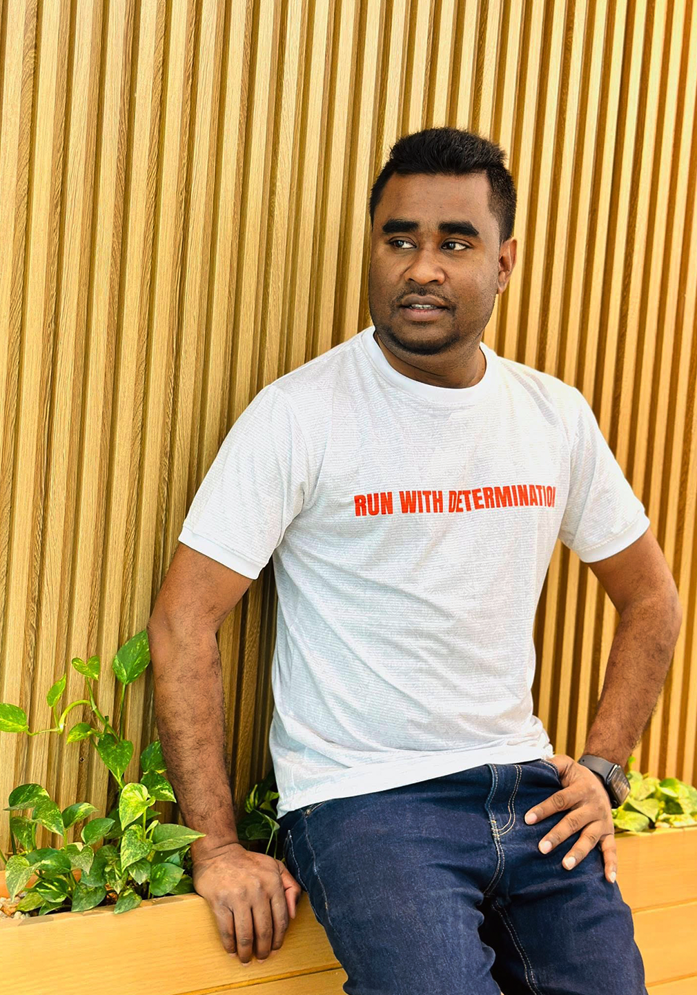 White T-shirt with orange text reading "Run With Determination" and rickshaw paint all over the body.