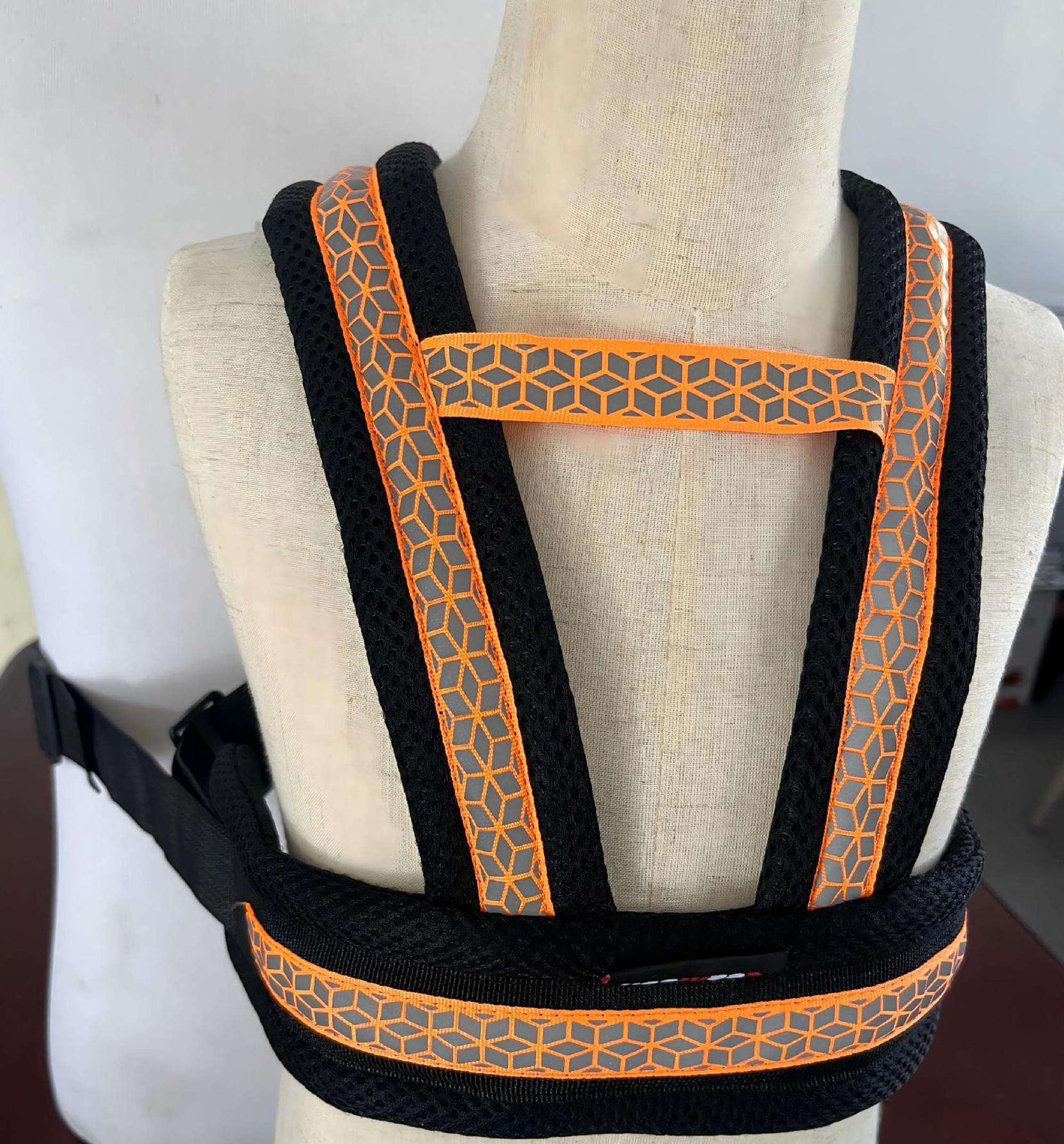 Close-up display of the adjustable shoulder straps and reflective pattern on a mannequin.