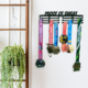 Proof of Sweat black metal medal hanger display unit showing 18 inch width and 5 inch height dimensions
